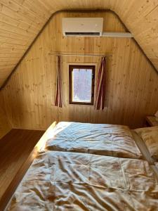 a large bed in a room with a window at Chata v údolí in Rozbehy