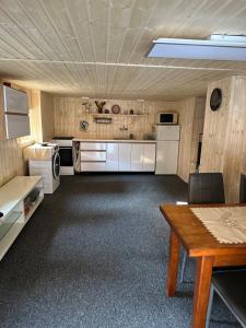 a large kitchen with white appliances and a table at Chata v údolí in Rozbehy