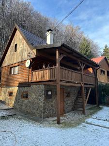 a large wooden house with a balcony on top at Chata v údolí in Rozbehy