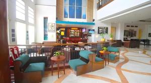 Un vestíbulo con sillas y un bar en un edificio. en Grand Surya Hotel Kediri, en Kediri