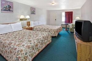 una camera d'albergo con due letti e una TV a schermo piatto di Knights Inn South Houston TX a Houston