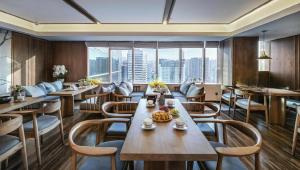 a restaurant with tables and chairs and a large window at Grand Holiday Hotel in Shenzhen