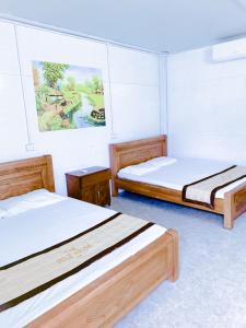 ein Zimmer mit zwei Betten und einem Gemälde an der Wand in der Unterkunft The Gold House Tam Đảo in Tam Ðảo