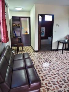 een woonkamer met een leren bank en een tafel bij Kata Lina rooftop in Kata Beach