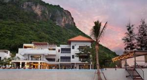 Num SauHansar Pranburi的山前有棕榈树的建筑