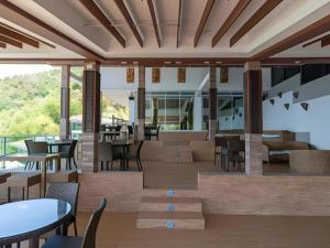 ein Restaurant mit Tischen und Stühlen auf einer Terrasse in der Unterkunft Anilao Awari Bay Resort in Pulonganahao