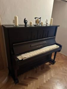 布尔诺Lounge Piano Apartment的一架黑色钢琴，上面放着蜡烛。