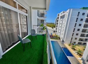 a balcony with green grass and two chairs at Mombasa Nyali opp Baobab Resort in Mombasa