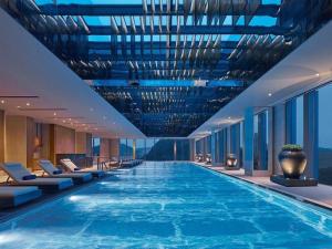 una grande piscina in un hotel con sedie di New World Guiyang Hotel a Guiyang
