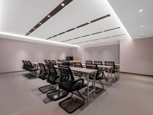 泉州Jinjiang Inn Quanzhou West Street Kaiyuan Temple的一间有桌子和椅子的会议室