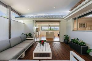 a living room with a couch and a table at Forresters Lodge by Coast Hosting in Wamberal North