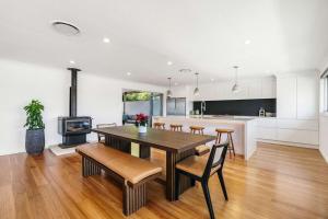 a kitchen and dining room with a table and chairs at Forresters Lodge by Coast Hosting in Wamberal North
