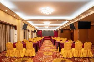 a conference room with rows of chairs and a screen at Fu Yuan Hotel in Dongguan
