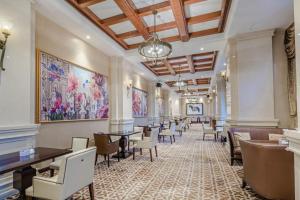 a dining room with tables and chairs and paintings on the walls at Yin Run Jin Jiang Castle Hotel in Huangshu