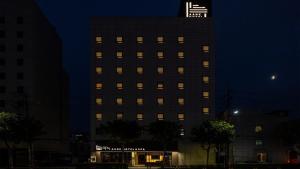 首尔Aank Hotel and Spa Seoul Seongsu Konkuk University的一座高大的建筑,上面有灯,晚上