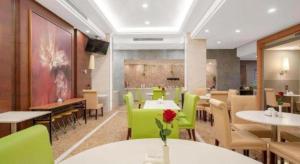 ein Esszimmer mit Tischen und grünen Stühlen in der Unterkunft Jinjiang Inn Select Shanghai Expo Park Dezhou Road in Shanghai