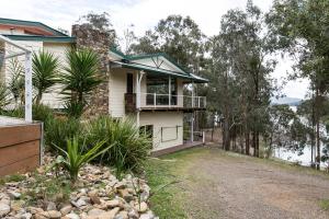 a house with a balcony on the side of a road at Devinegetaway in Eildon