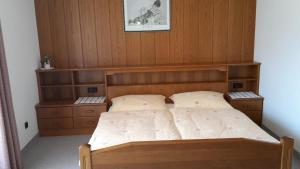 a bedroom with a bed with a wooden headboard at Ferienwohnungen Gudrun Bernhard in Berg im Drautal