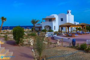 a white building with a lot of tables and chairs at Beach safari suites &expedition in Marsa Alam City