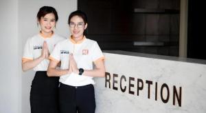 duas mulheres em pé em frente a uma placa de inscrição em B2 Phrae Boutique and Budget Hotel em Ban Nam Khong