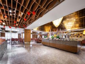 ein Restaurant mit Bar sowie Tischen und Stühlen in der Unterkunft Ramada Plaza By Wyndham Fuzhou South in Fuzhou