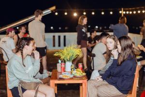 un gruppo di persone seduti intorno a un tavolo di Phong Nha Garden House a Phong Nha