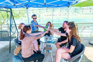 un gruppo di persone seduti intorno a un tavolo con bevande di Phong Nha Garden House a Phong Nha