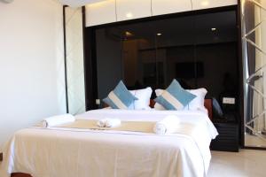 1 dormitorio con 1 cama grande con sábanas blancas y almohadas azules en SETRA Hotel, en Banlung