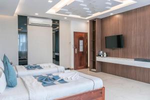 una habitación de hotel con dos camas y un televisor en SETRA Hotel, en Banlung