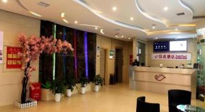 a lobby with a waiting area with flowers in a hospital at Shell Ganzhou Central Theme Hotel in Ganzhou
