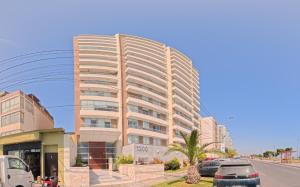 a tall building with cars parked in front of it at Ocean Blue, Vista Frontal Al Mar in Lima
