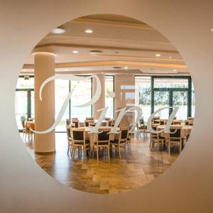 comedor con mesas, sillas y espejo en Hotel Pina Ristorante, en Isola del Gran Sasso dʼItalia