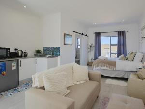 a living room with a couch and a bed at Blouberg, Nautica and Studio Apartments in Cape Town