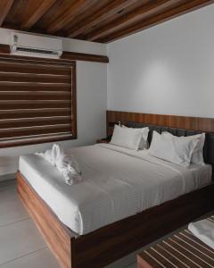 IrimbranallūrMayanadhi Resort的一间卧室，床上躺着一只狗