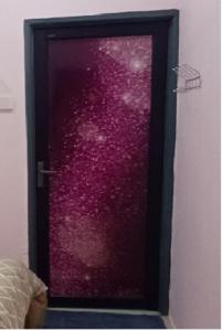 eine rote Glastür vor violettem Hintergrund in der Unterkunft Lavender Splash Homestay in Ipoh