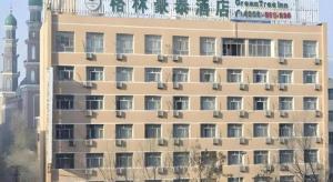 乌鲁木齐GreenTree Inn Urumqi South Xinhua Road Hotel的一座顶上有钟的高楼