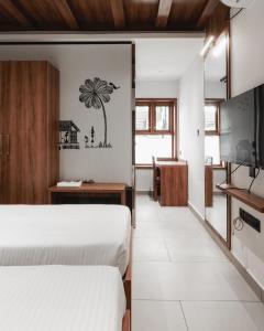 IrimbranallūrMayanadhi Resort的一间有两张床和一台电视的酒店房间