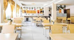 Ban Dông-NaxôkJian Guo Grand Hotel的餐厅里有桌椅的餐厅