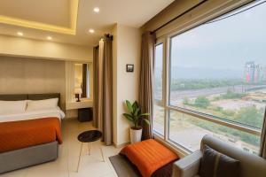 a hotel room with a bed and a large window at Montressa Executive Stay - Gold Crest Mall Phase 4 Lahore in Lahore