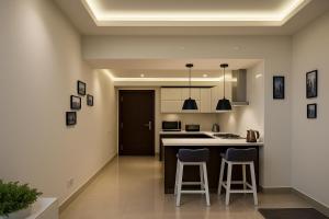 a kitchen with two bar stools and a counter top at Montressa Executive Stay - Gold Crest Mall Phase 4 Lahore in Lahore