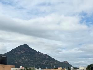 a mountain in the distance with a cloudy sky at ShivOhome in Tiruvannāmalai