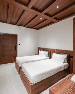 IrimbranallūrMayanadhi Resort的房间里有两张床，天花板是木制的