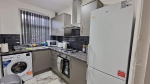 a kitchen with a refrigerator and a washing machine at Nice Living Serviced Accommodations Birmingham 2 in Birmingham