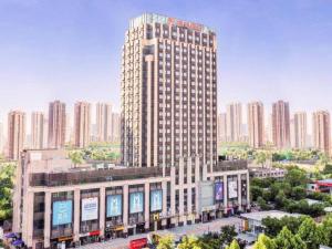 a tall building in a city with tall buildings at Moqi Hotel Wuhan in Wuhan
