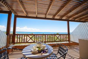 einen Tisch und Stühle auf einem Balkon mit Meerblick in der Unterkunft Althea Apartments in Katakolo