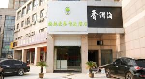 a building with cars parked in front of it at GreenTree Inn Nanjing Baijiahu in Jiangning