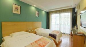 Un dormitorio con dos camas y un televisor de pantalla plana. en Shell Hefei Luyang District Sipai Building Subway Station Hotel, en Hefei