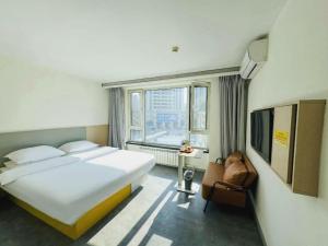 哈尔滨7 Days Inn Harbin West Railway Station的一间卧室，配有一张大床和一扇大窗户。