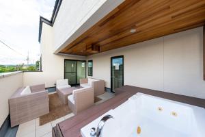 a room with a bath tub and a living room at Kotohaku 木津町 in Kizugawa