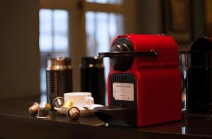 eine rote Kaffeemaschine und eine Tasse auf dem Tisch in der Unterkunft The Keong Saik Hotel in Singapur